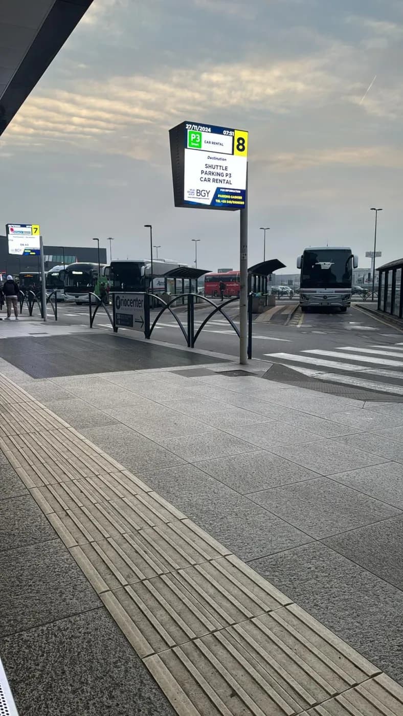 Busbahnhof am Flughafen Bergamo (BGY) mit Reisebussen und Anzeigetafel für Shuttle, Parken und Mietwagen