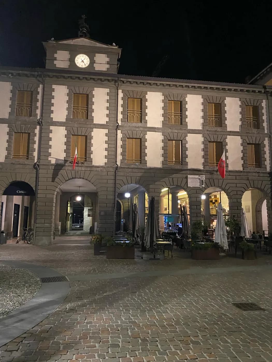 Das beleuchtete Rathaus von Iseo (1830) mit Uhrturm und Arkaden bei Nacht