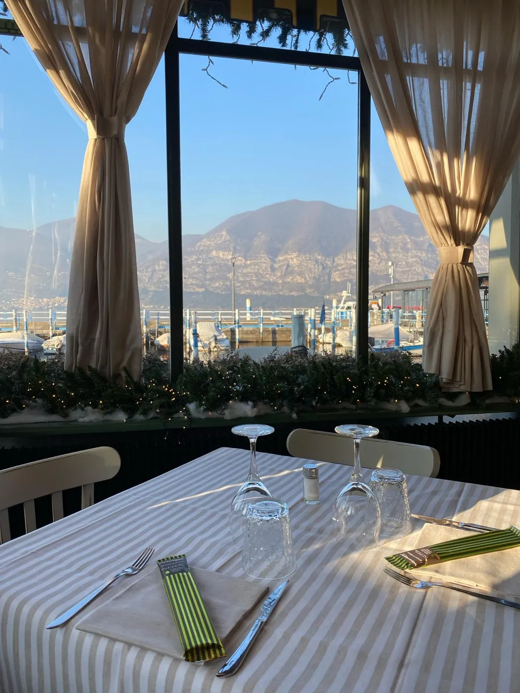 Gedeckter Tisch am Fenster im Ristorante Leon d’Oro in Iseo mit Blick auf Hafen und Monte Isola